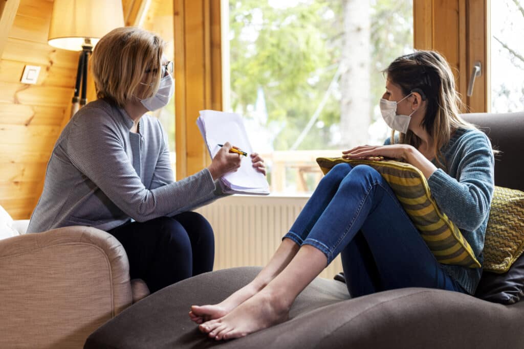 A young woman in a session with a psychologist talking about alcohol outpatient treatment