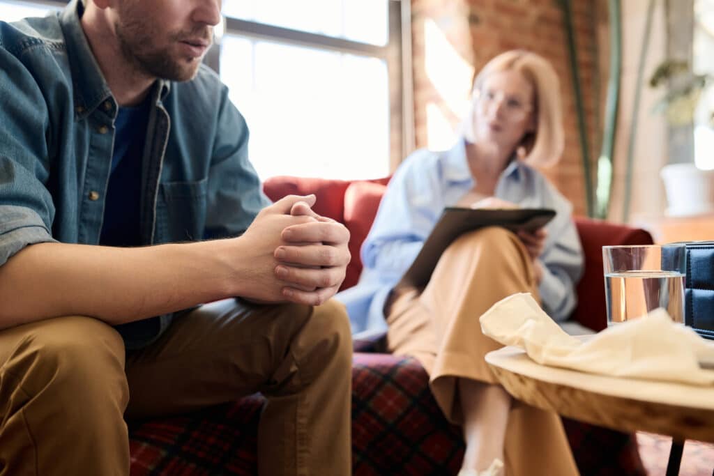 Man talking to psychologist at session of Cognitive Behavioral Therapy