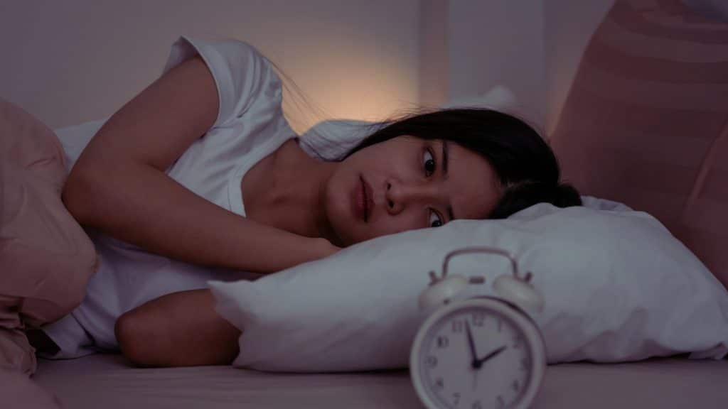 Person lying awake in bed, illustrating insomnia linked to Adderall addiction symptoms