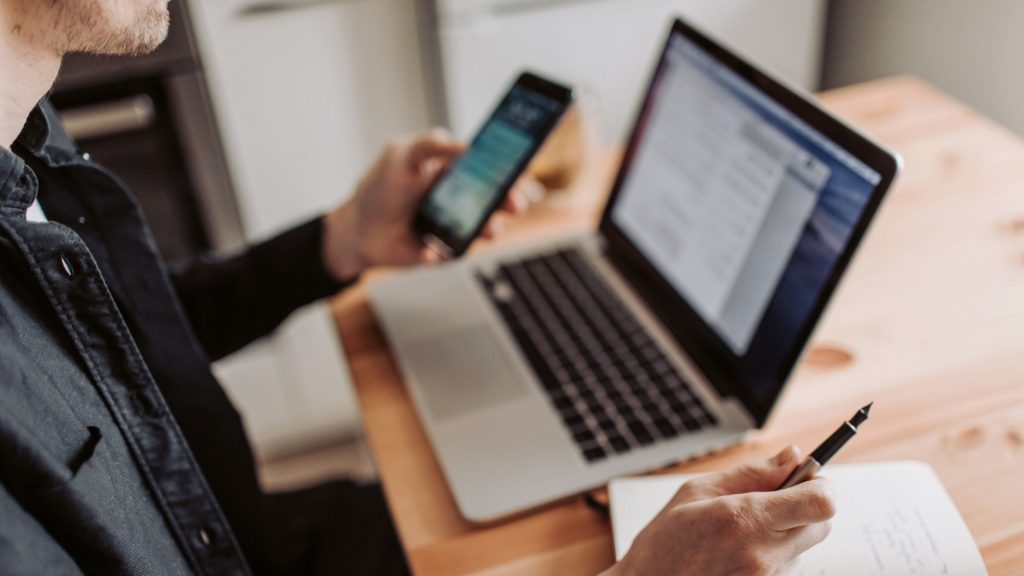 Person organizing schedules and paperwork while preparing for a PHP