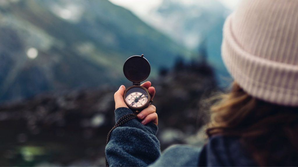 How Long Does an Intensive Outpatient Program Last? 2 Person holding a compass while navigating a path, symbolizing guidance during an intensive outpatient program.