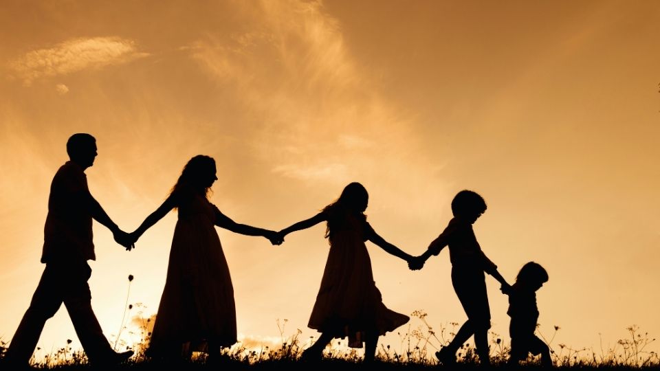 Is Alcoholism Hereditary hero image of a family representing the genetic lineage of addiction walking through a field.