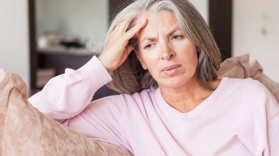 a woman experiences the stages of alcoholism over time, resting on a couch.