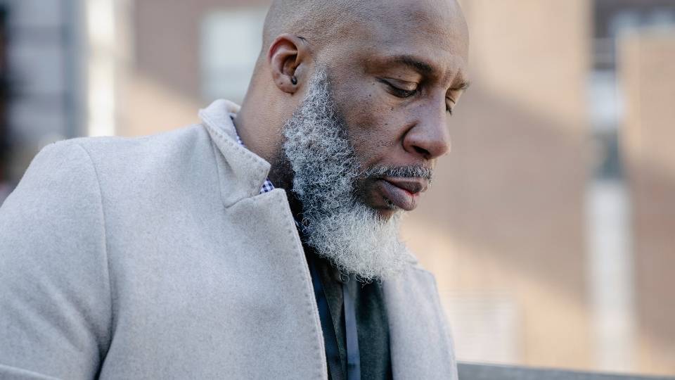 Heroin Withdrawal Timeline hero image of a man looking down.
