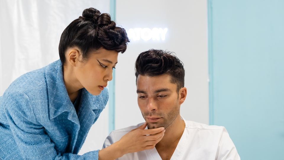 Dermatologist examining facial skin redness in a patient with an alcoholic nose, also called rhinophyma.